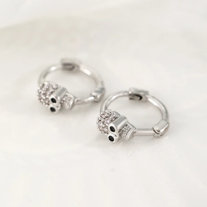 Macro detail of gothic skull earrings with silver finish and black crystals