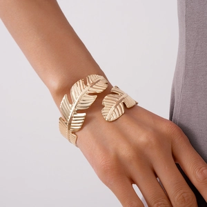Detailed view of golden leaf cuff bracelet with intricate vein textures on model wrist