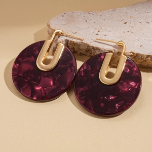Detail of round tortoiseshell acetate earrings with 18K gold plated metal components