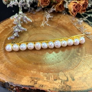 Elegant natural freshwater pearl hair clip on rustic wood with floral accents