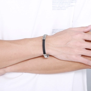 Détail du bracelet en acier inoxydable tressé avec maille argentée et accents noirs mats