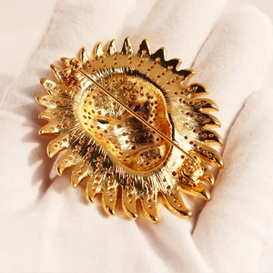 Luxurious gold lion head brooch with sparkling cubic zirconia pavé setting in hand