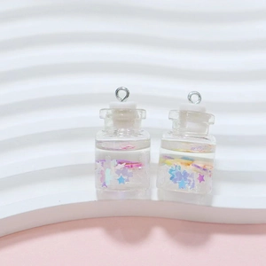 Macro shot of mini drifting bottle charms with colorful star sequins and liquid filling