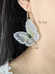 Detail showing crystal beaded butterfly earrings measuring 6.7cm by 4.3cm on a model