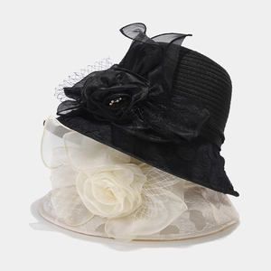 Detail of organza floral fascinator hats for women with pearls and mesh on striped fabric
