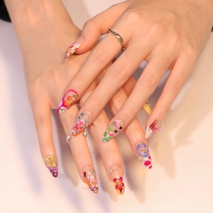 Faux ongles 3D fleurs tropicales avec papillons, strass et perles sur forme stiletto