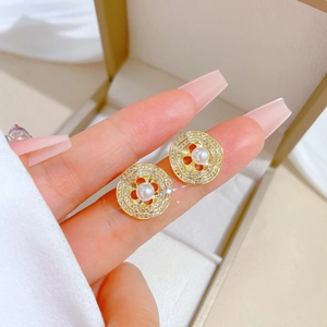Macro detail of gold round pearl earrings with micro-inlaid white zircon crystals