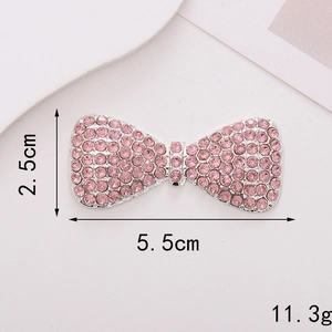 Macro detail of pink rhinestone bow charm showing 5.5cm length and 2.5cm height dimensions