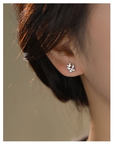 Detailed close-up of double butterfly stud earrings with shiny cubic zirconia stones