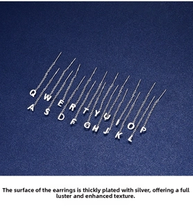 Detail of S999 sterling silver letter tassel earrings with polished thick silver plating