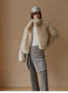 Detail of plush faux fur vest in beige apricot with soft texture and stand collar