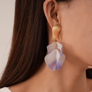 Detail view of long petal drop earrings with purple gradient and matte gold finish