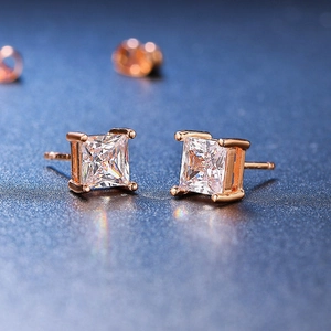Macro shot of rose gold square-cut zircon stud earring with four-prong setting