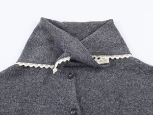 Close-up of dark grey knit cardigan featuring a sailor collar with white lace trim and buttons