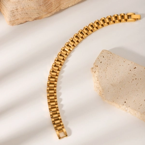 Bracelet luxueux en acier inoxydable plaqué or 18 carats sur support en travertin chic