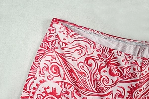 Vue détaillée de l'imprimé paisley rouge et blanc avec couture d'ourlet sur tissu tricoté