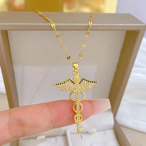Close-up of golden Caduceus pendant with black and clear crystals on a matching chain