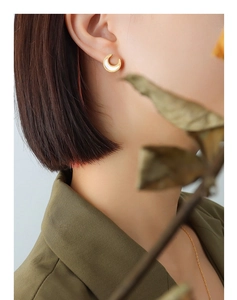 Close-up of 18K gold plated crescent moon earrings with white shell inlay on model