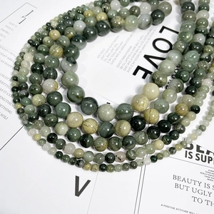 Multiple sizes of natural green grass stone beads arranged in a circular layout for jewelry