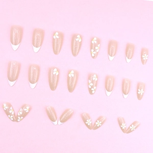 Faux ongles French avec marguerites blanches et paillettes sur base rose nude