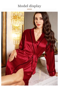 Close-up of wine red silk satin robe with black trim and matching waist tie in hotel