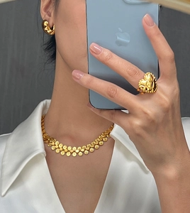 Detail view of gold titanium jewelry set featuring a heart ring and floral necklace