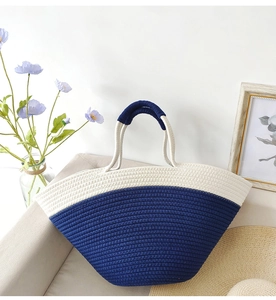 Detail of navy and beige woven cotton rope tote bag in a casual beach-style setting