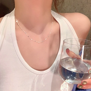 Collier à paillettes argentées minimaliste sur un modèle avec détails brillants et chaîne fine