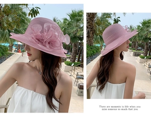Detail of pink organza beach hat featuring a large 3D flower and wide brim for sun protection