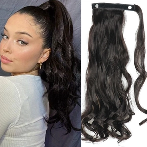 Detail of curly ponytail extension with velcro strap and wavy texture in dark brown