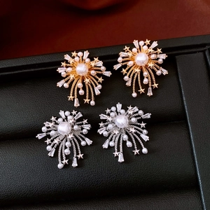Detailed macro of 18k gold and silver firework earrings with pearls and zircons