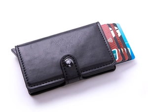 Detail of black leather card holder showing the pop-up aluminum mechanism and snap button