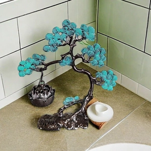 Artistic dark bronze pine tree incense burner with green pine needles and hanging lotus box