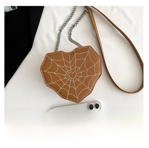 Detalle del bolso bandolera con forma de corazón, costuras blancas y correa de cadena
