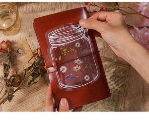 Retro PET flower sticker in mason jar shape on a vintage leather journal background