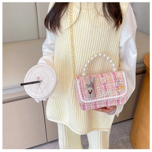 Detailed texture of pink tweed girls handbag with pearl handle and rabbit charm