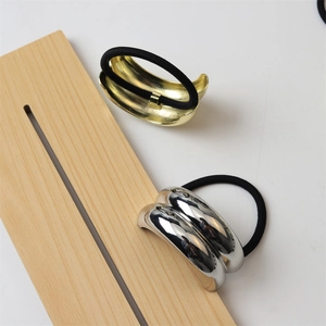 Detail of minimalist gold and silver hair ties with polished metallic semi-circle accents