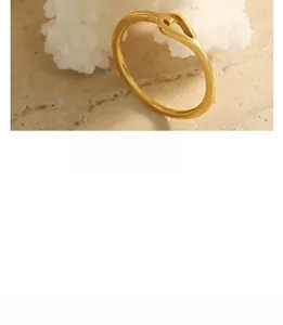 Macro detail of a minimalist gold ring with a stylish twisted knot design on the band
