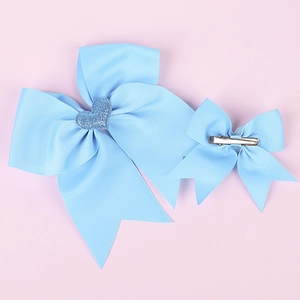 Detailed view of blue grosgrain ribbon bows with heart sequins and metal hair clip