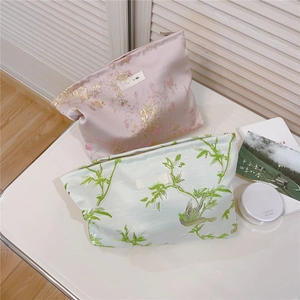 Gros plan sur les détails de broderie jacquard des trousses à maquillage à fleurs