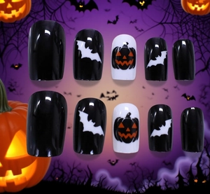 Detail of Halloween press-on nails featuring pumpkin and bat designs on a purple background