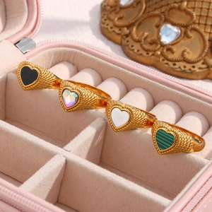 Detail of twisted gold rings featuring heart-shaped stone inlays in a pink jewelry box
