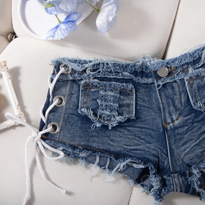 Dettaglio degli shorts in denim blu scuro con lacci laterali e orlo a frange consumato