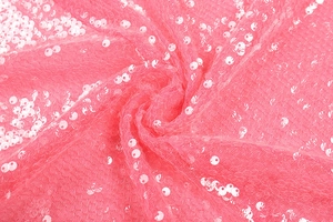 Macro shot of pink sequin fabric details with mesh ruffles and shimmering textures