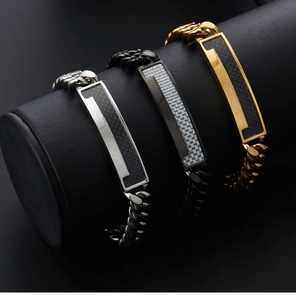 Detailed view of silver, black and gold Cuban link bracelets with carbon fiber inlay