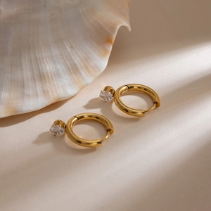 Elegante 18K vergoldete Edelstahl-Ohrringe mit weißem Zirkon auf beigem Hintergrund