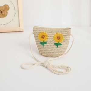 Dettaglio di borsa a tracolla in paglia per bambini con applicazioni di girasole
