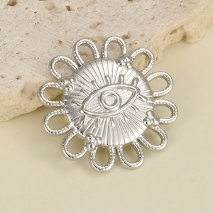 Macro detail of a silver stainless steel evil eye pendant with sunburst engraving
