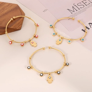Detailed macro view of three 18K gold-plated twisted bangles with colorful Evil Eye charms