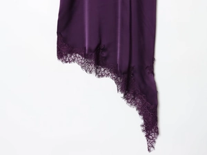 Détail de l'ourlet en satin violet foncé avec dentelle de cils délicate et coupe irrégulière